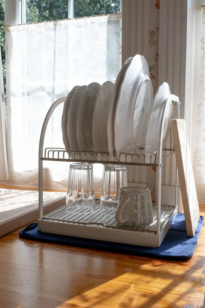 Vintage-inspired dish rack with dishes in sunlight, capturing nostalgic home vibes.