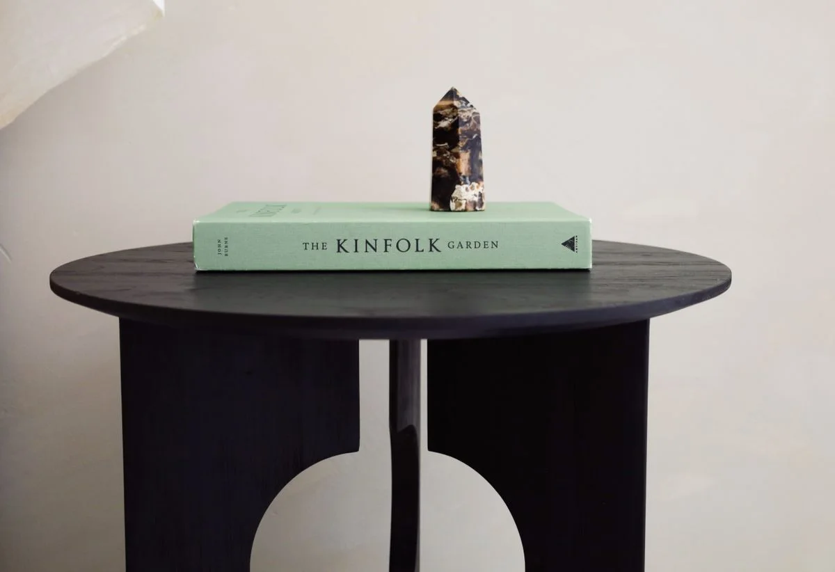 Minimalist interior design featuring a side table with a book and decorative stone, perfect for modern homes.