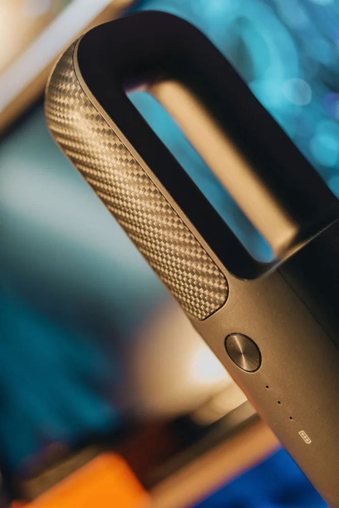Closeup details of stylish modern matte black portable vacuum cleaner against blurred background