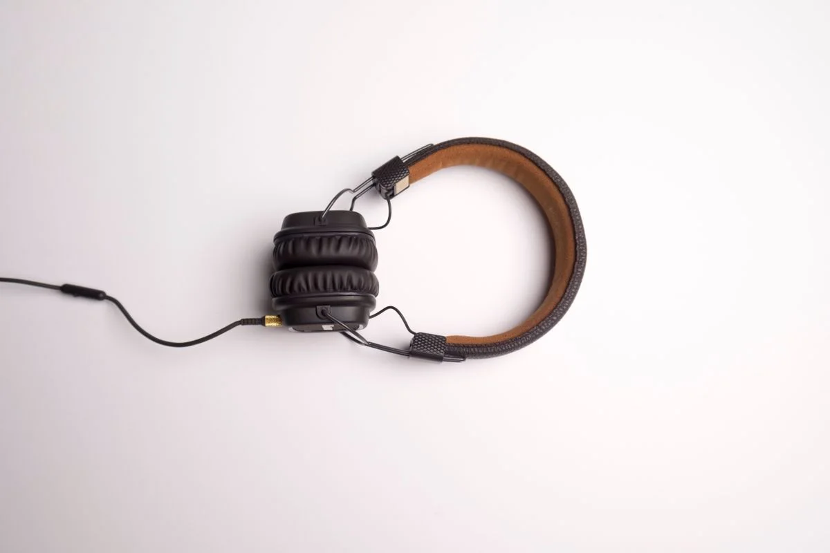 Minimalist image of black over-ear headphones on a white background.