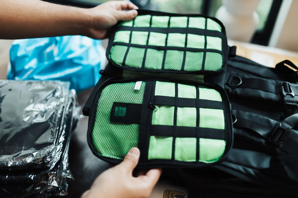 Close-up of hands organizing a travel luggage with packing cubes for efficient packing.